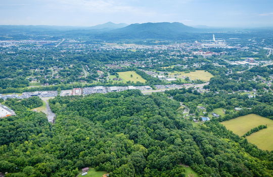 aerial photo, undeveloped land, 48+/- acres, commercial land for sale, trees, neighboring businesses, stone drive, mountain views, 1100'+ Road Frontage, prime Kingsport Location