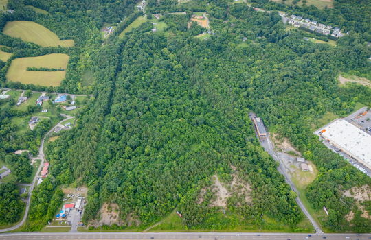 aerial photo, undeveloped land, 48+/- acres, commercial land for sale, trees, neighboring businesses, stone drive, mountain views, 1100'+ Road Frontage