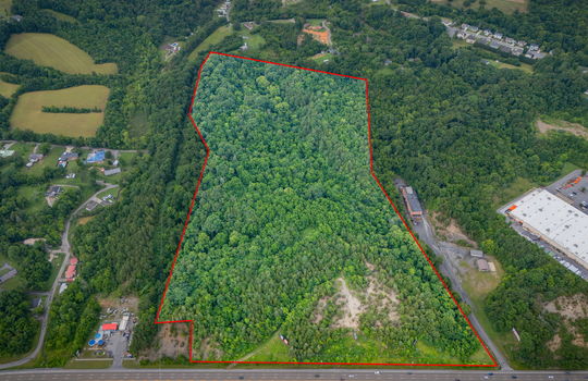 aerial photo, undeveloped land, 48+/- acres, commercial land for sale, trees, neighboring businesses, stone drive, mountain views, 1100'+ Road Frontage, property outline, overhead aerial view