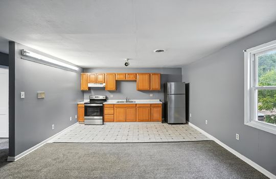 kitchen, vinyl flooring, refrigerator, oven/range, cabinets, countertops, sink, window, living room, carpet