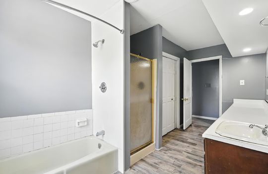 bathroom, shower, shower/tub, sink, closet, luxury vinyl flooring