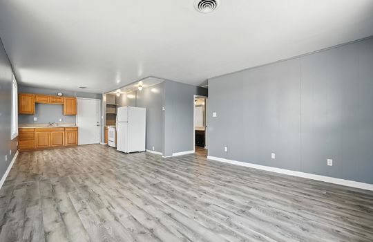 open concept studio apartment, living room, kitchen, cabinets, countertops, sink, oven/range, refrigerator, hallway