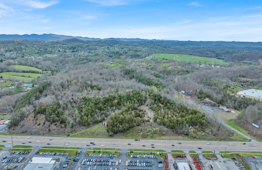 aerial photo, undeveloped land, 48+/- acres, commercial land for sale, trees, neighboring businesses, stone drive, mountain views, 1100'+ Road Frontage
