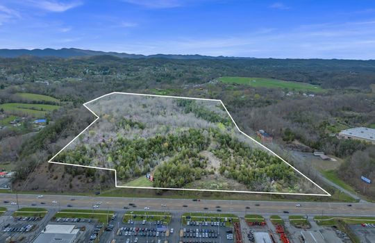 aerial photo, undeveloped land, 48+/- acres, commercial land for sale, trees, neighboring businesses, stone drive, mountain views, 1100'+ Road Frontage, property outline