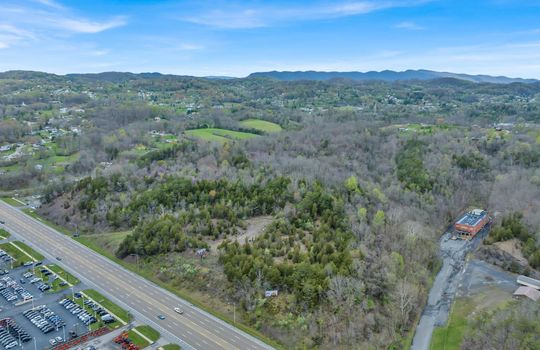 aerial photo, undeveloped land, 48+/- acres, commercial land for sale, trees, neighboring businesses, stone drive, mountain views, 1100'+ Road Frontage