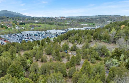 aerial photo, undeveloped land, 48+/- acres, commercial land for sale, trees, neighboring businesses, stone drive, mountain views, 1100'+ Road Frontage