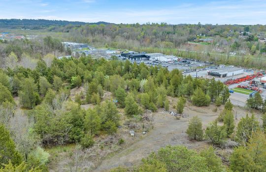 aerial photo, undeveloped land, 48+/- acres, commercial land for sale, trees, neighboring businesses, stone drive, mountain views