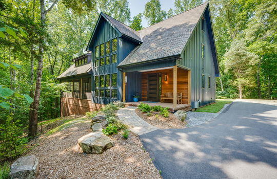 contemporary home, wood siding, metal siding, trees, driveway, screened porch, landscaping, front door