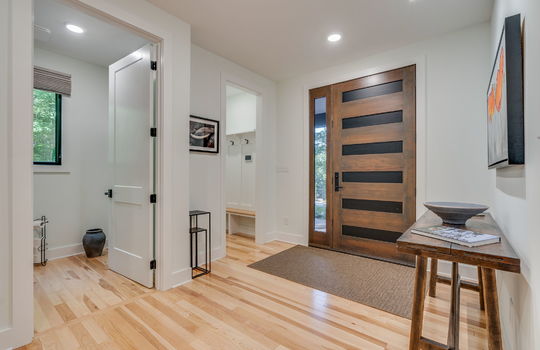 front door, mud room, half bath, hardwood flooring