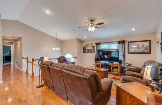 living room, hardwood flooring, foyer stairs, ceiling fan, hallway, vaulted ceiling, recessed lighting