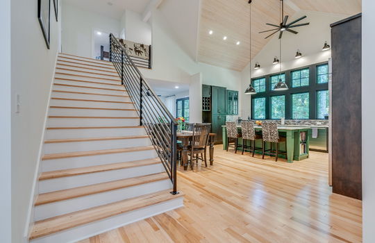 foyer, stairs to upper level, kitchen, vaulted ceiling, dining space, ceiling fan