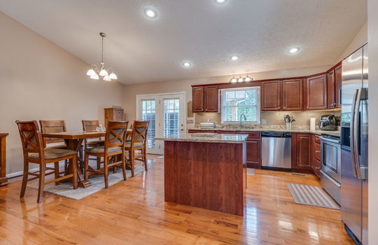 kitchen, kitchen island, granite countertops, sink, refrigerator, oven/range, dishwasher, cabinets, countertops, window above sink, hardwood flooring, dining space, door to back deck