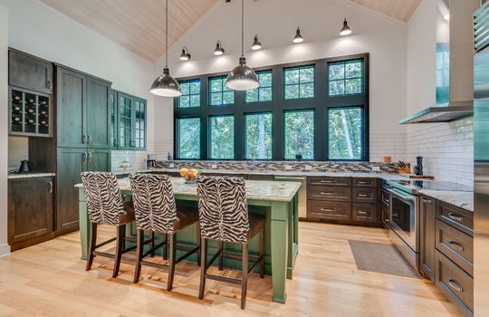 kitchen, kitchen island, commercial grade appliances, refrigerator, oven/range, microwave, dishwasher, kitchen island, windows, cabinets, tile backsplash, granite countertops, hardwood flooring