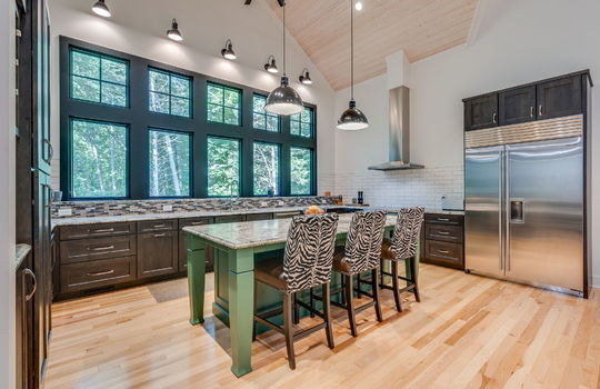 kitchen, kitchen island, commercial grade appliances, refrigerator, oven/range, microwave, dishwasher, kitchen island, windows, cabinets, tile backsplash, granite countertops, hardwood flooring