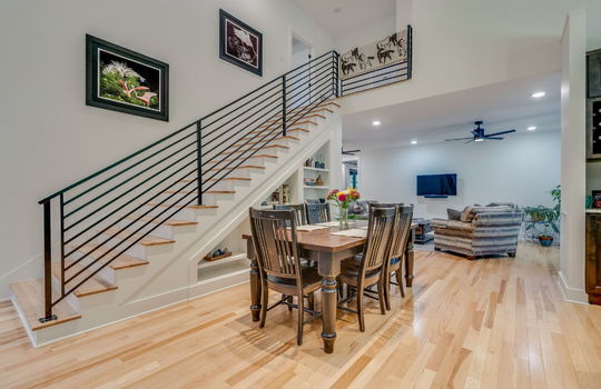 main home, foyer, open concept, stairs to upper level, dining area, built in shelving, living room, kitchen