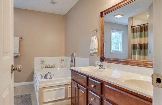 primary bathroom, double sink/vanity, cabinets, garden tub, tile flooring