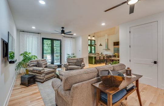 living room, open to kitchen, doorway to back deck, hardwood flooring, ceiling fans, recessed lighting