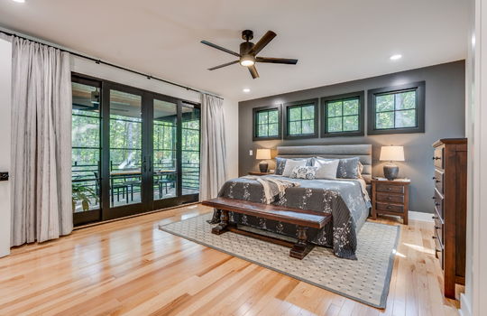 primary bedroom, door to back deck, ceiling fan, hardwood flooring, windows