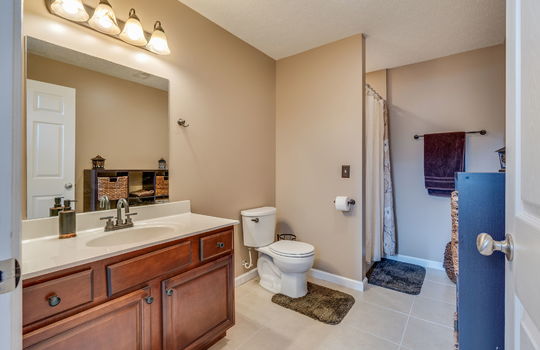 lower level bathroom, toilet, tile flooring, sink, shower