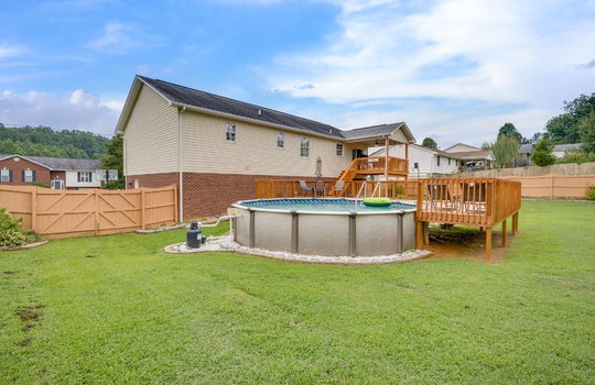 back yard, fully fenced back yard, pool, deck for pool, covered back deck, back door, landscaping, vinyl siding, brick