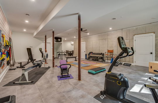 basement living area, recreation room, concrete flooring, concrete walls, recessed lighting