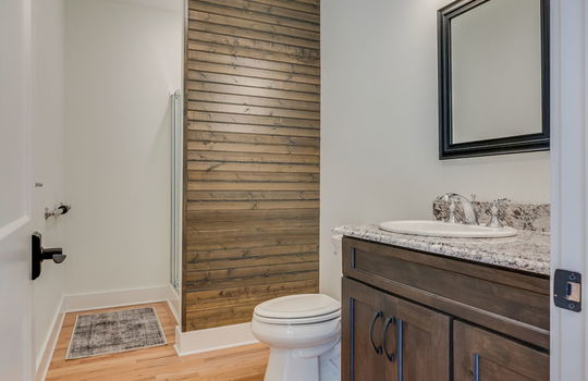 guest home, bathroom, shower, toilet, sink, granite countertops, cabinet, hardwood flooring