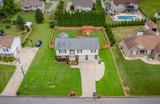 aerial photo from street, driveway, mailbox, front yard, fenced back yard, split foyer, roof, vinyl siding, brick, back deck, pool with deck, storage shed