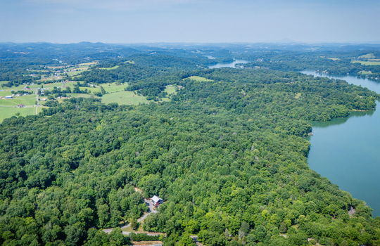 aerial view of property, neighboring properties, lake, mountains