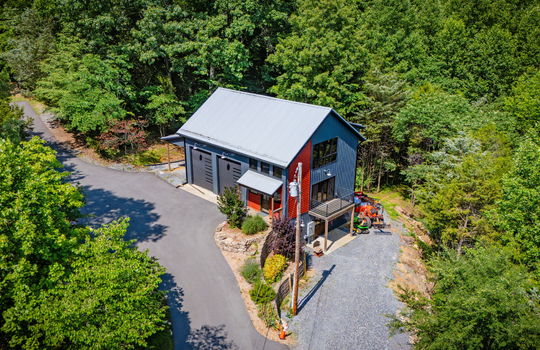 Aerial view of guest home, contemporary home, two car garage, back deck, driveway, trees, covered front porch