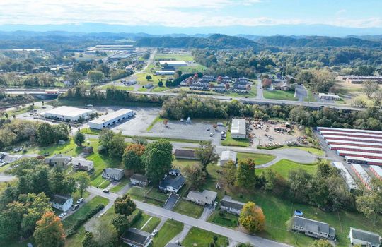 aerial view of property, road, neighboring homes, neighboring businesses, mountains