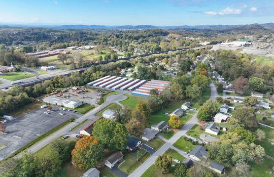 aerial view of property, road, neighboring homes, neighboring businesses, mountains