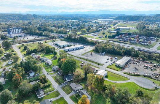 aerial view of property, road, neighboring homes, neighboring businesses, mountains