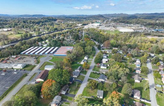 aerial view of property, road, neighboring homes, neighboring businesses, mountains