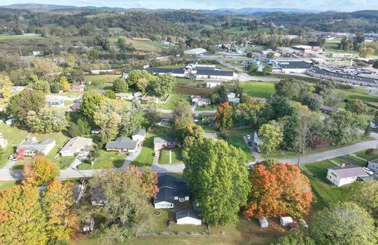 aerial view of property, road, neighboring homes, neighboring businesses, mountains