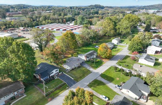 aerial view of property, road, neighboring homes, neighboring businesses, mountains