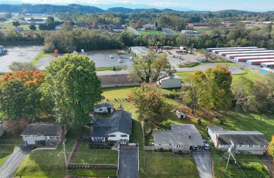 aerial view of property, road, neighboring homes, neighboring businesses, mountains