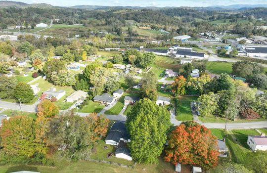 aerial view of property, road, neighboring homes, neighboring businesses, mountains