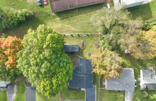 Aerial view of property, overhead view, front yard, driveway, roof, back yard, landscaping, trees, neighboring homes