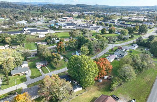 aerial view of property, road, neighboring homes, neighboring businesses, mountains