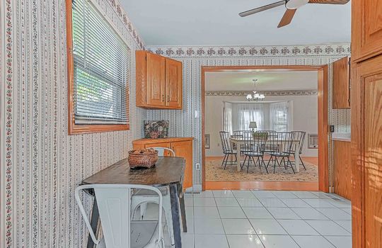 breakfast nook, cabinets, tile flooring, ceiling fan, window, view into dining room
