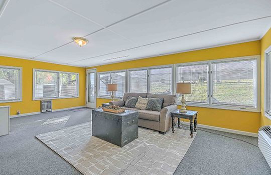 heated sunroom, windows, exterior door, indoor/outdoor carpet, built-in shelving