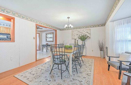 Dining room, doorway into kitchen, chandelier, hardwood flooring