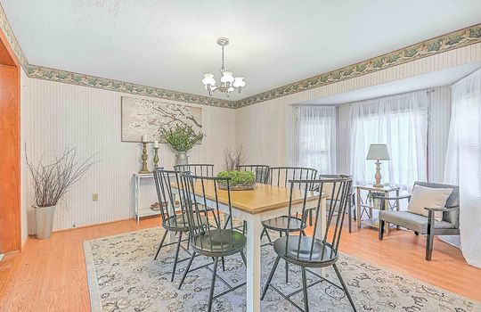 Dining room, doorway into kitchen, chandelier, hardwood flooring
