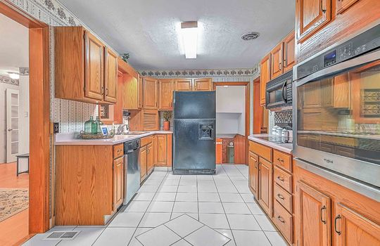 kitchen, tile flooring, cabinets, countertops, refrigerator, built-in microwave, wall oven, cooktop, fluorescent lighting