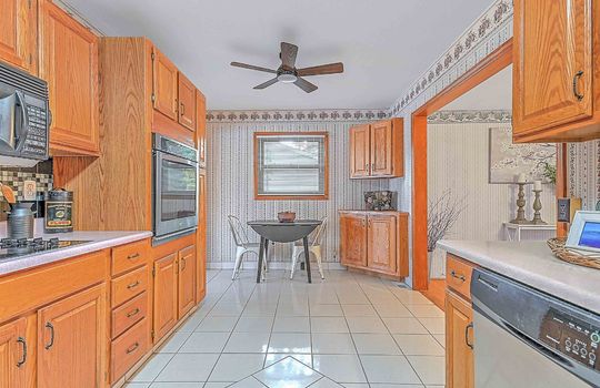 kitchen, tile flooring, cabinets, countertops, wall oven, built in microwave, dishwasher, cooktop, ceiling fan