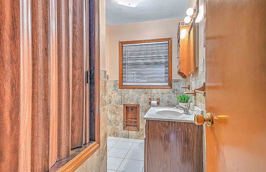 bathroom, tile walls, tile flooring, sink, toilet, shower/tub, tiled shower, window