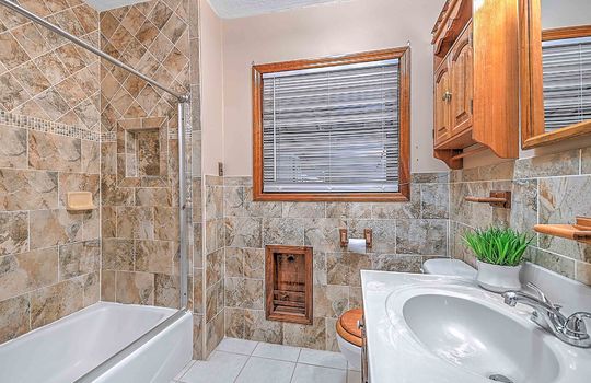 bathroom, tile walls, tile flooring, sink, toilet, shower/tub, tiled shower, window