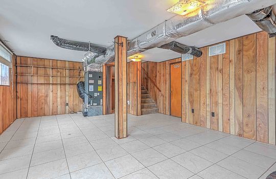 lower level walk-out basement, tile flooring, paneling walls, stairs to main level