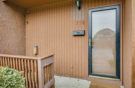 front porch, townhouse, storm door, wood siding, concrete exterior, landscaping