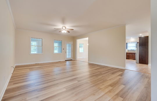 living room, hardwood flooring, ceiling fan, exterior door, doorway into kitchen